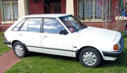 KB Ford Laser with non-factory wheelcovers.